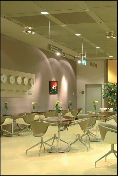 Cafeteria mit Tischen unter einer Streckgitterdecke