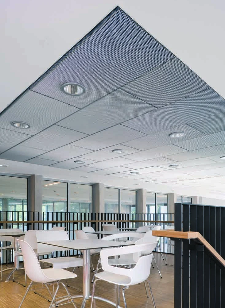 Heller Aufenthaltsbereich mit Decke aus Streckgitterplatinen und eingelassenen Leuchten