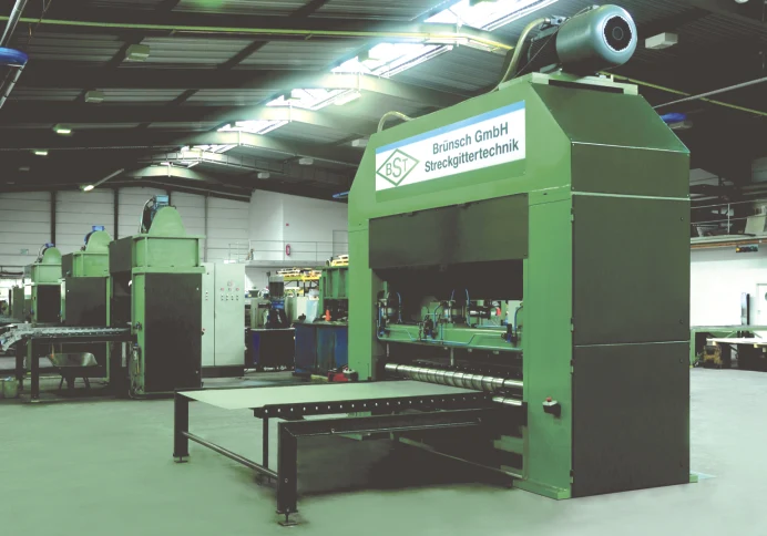 Grüne Streckgittermaschine mit der Aufschrift Brünsch GmbH Streckgittertechnik in der Fertigungshalle